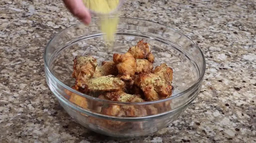 adding the lemon pepper to the wings